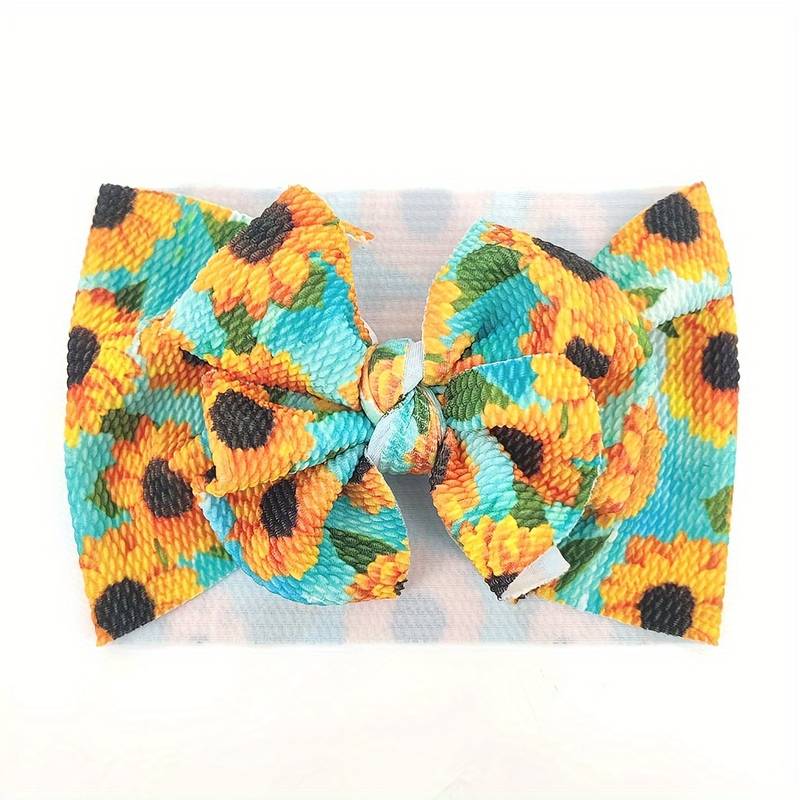 Baby bow headband with yellow sunflowers on blue green background