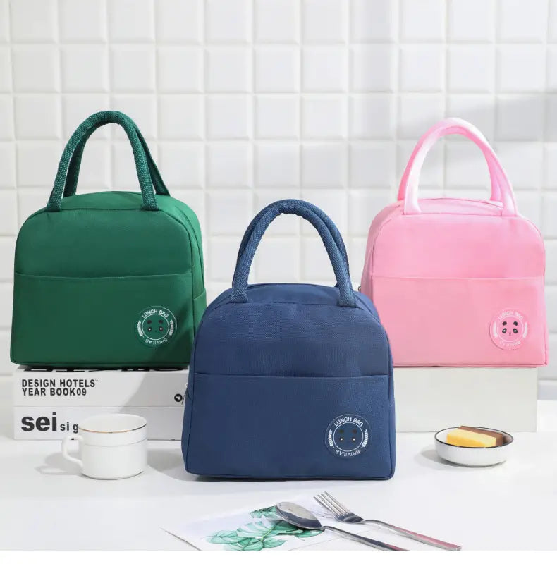 Three insulated lunch bags with handles. Green, Blue and Pink.